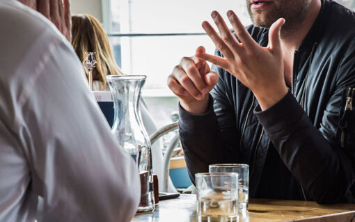 Three young professionals chatting around a cafe table